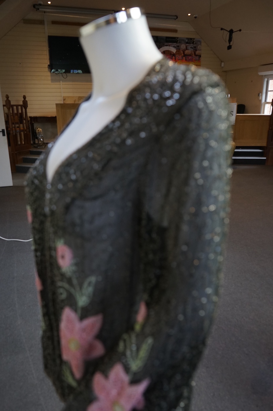A 1930’s, multi coloured floral hand beaded evening jacket, the beading worked on black georgette. Possibly French, label on the inside of the neck 48. 64cm long. Condition - beading and georgette appear in good conditio